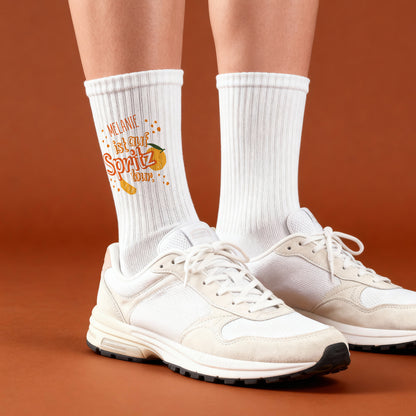 Personalisierte Spritz-Tour-Socken mit Namen, getragen mit weißen Sportschuhen.