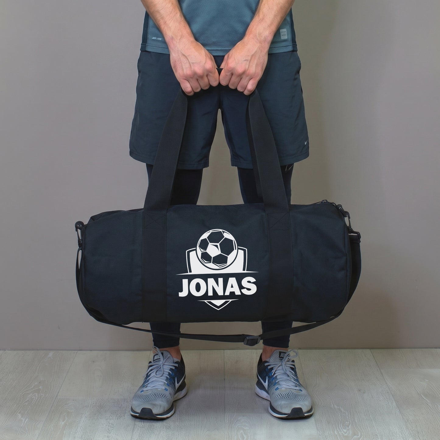 Mann hält personalisierte Fußballtasche mit Name Jonas in der Hand