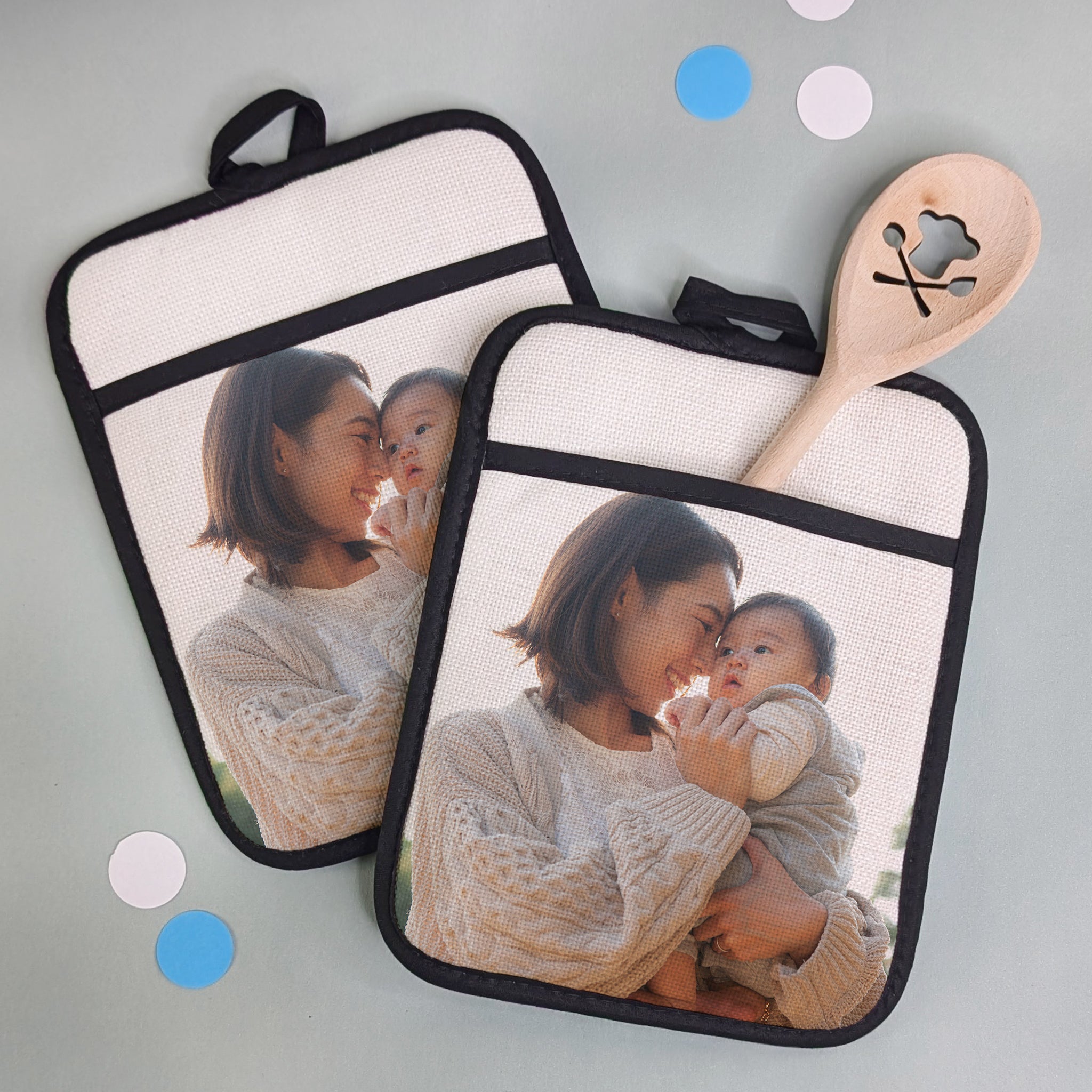 2 personalisierte Topflappen nebeneinander – mit eigenem Foto bedruckt, auf heller Unterlage