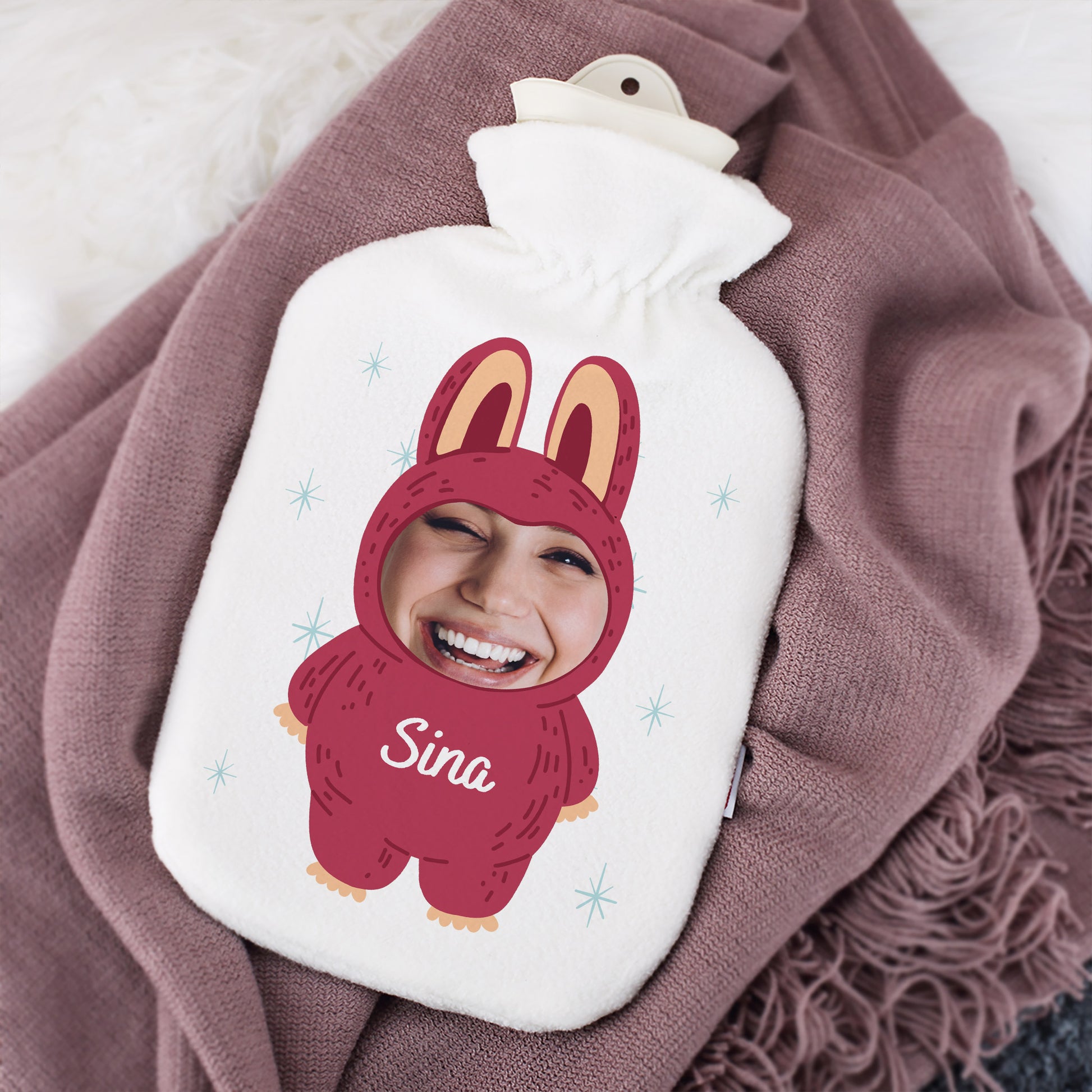 Personalisierte Wärmflasche mit Foto und Name „Sina“ im roten Monster-Design, dekoriert mit Decke