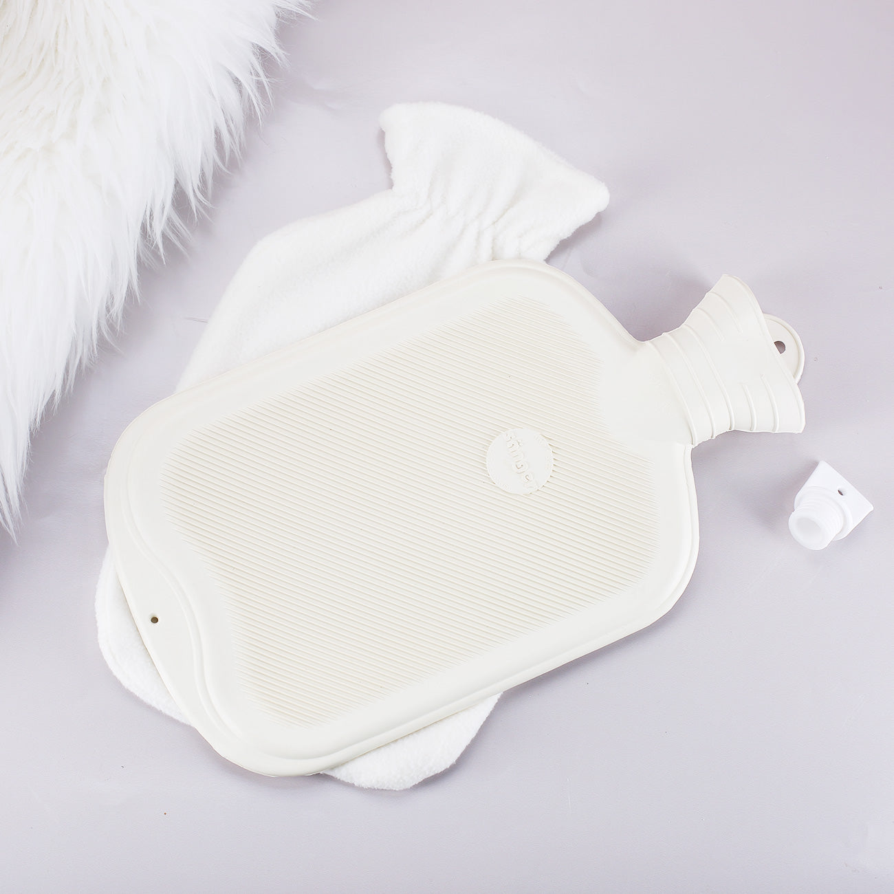 Rückseite der weißen Gummiwärmflasche mit abnehmbarem Bezug