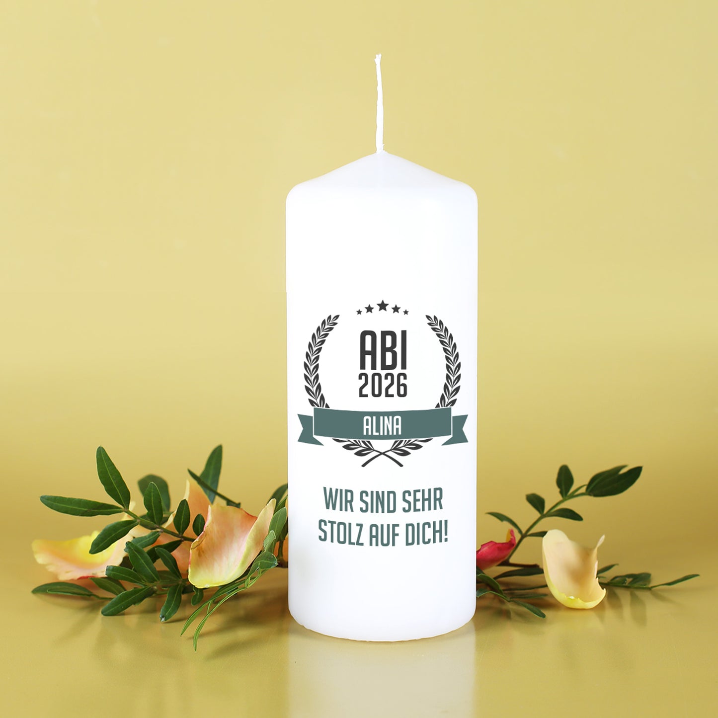 Abitur Kerze mit Name und Glückwunschtext vor gelbem Hintergrund mit Blumen