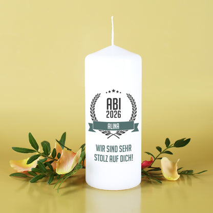 Abitur Kerze mit Name und Glückwunschtext vor gelbem Hintergrund mit Blumen