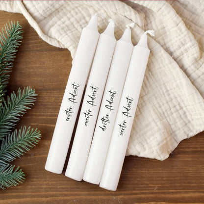 Weiße Adventskerzen im 4er-Set mit personalisierten Wunschtexten, dekorativ auf Holzuntergrund.