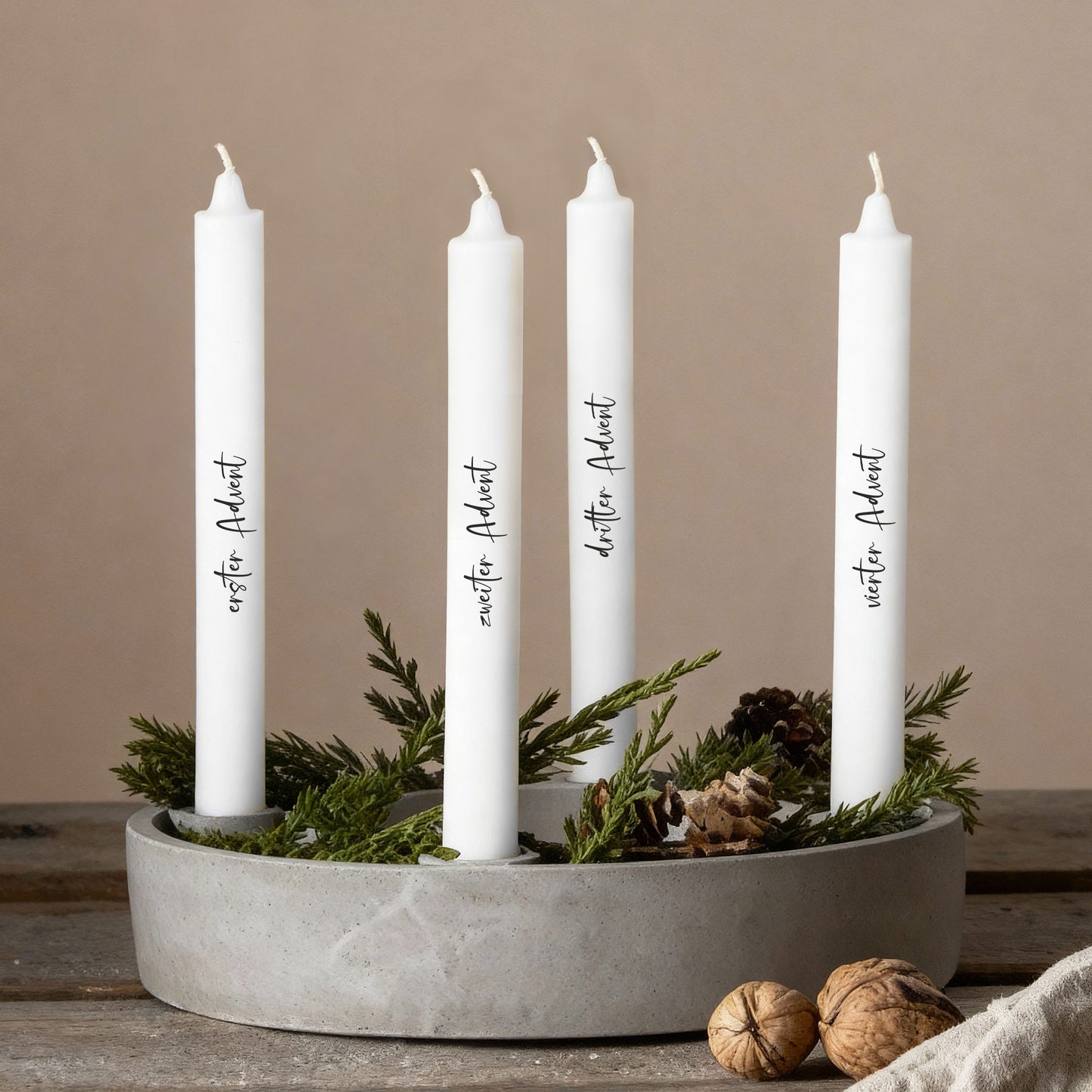 Adventskerzen mit individuellen Texten in modernem Kranz aus Naturmaterialien arrangiert.