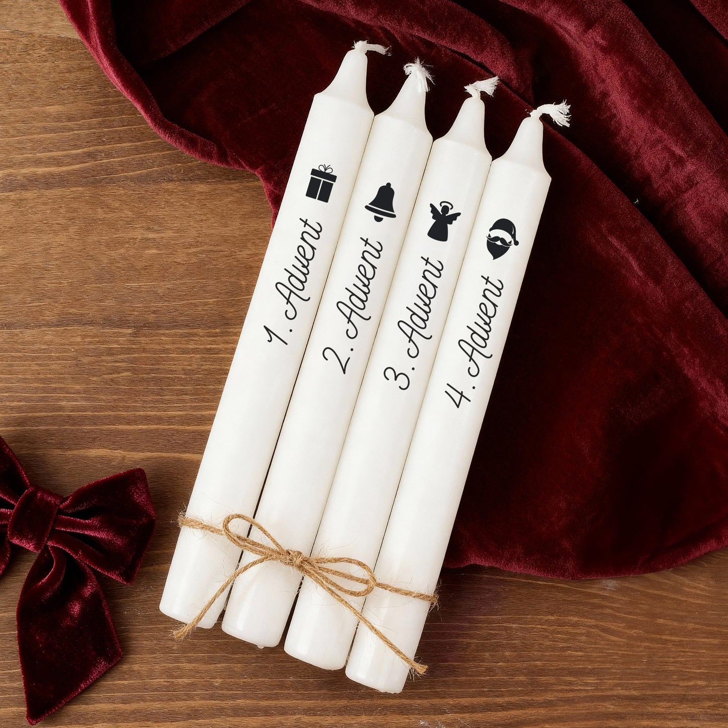 Weihnachtliche Adventskerzen mit Motiv Glocke, Engel und Weihnachtsmann liegend auf Holzuntergrund mit Dekoration