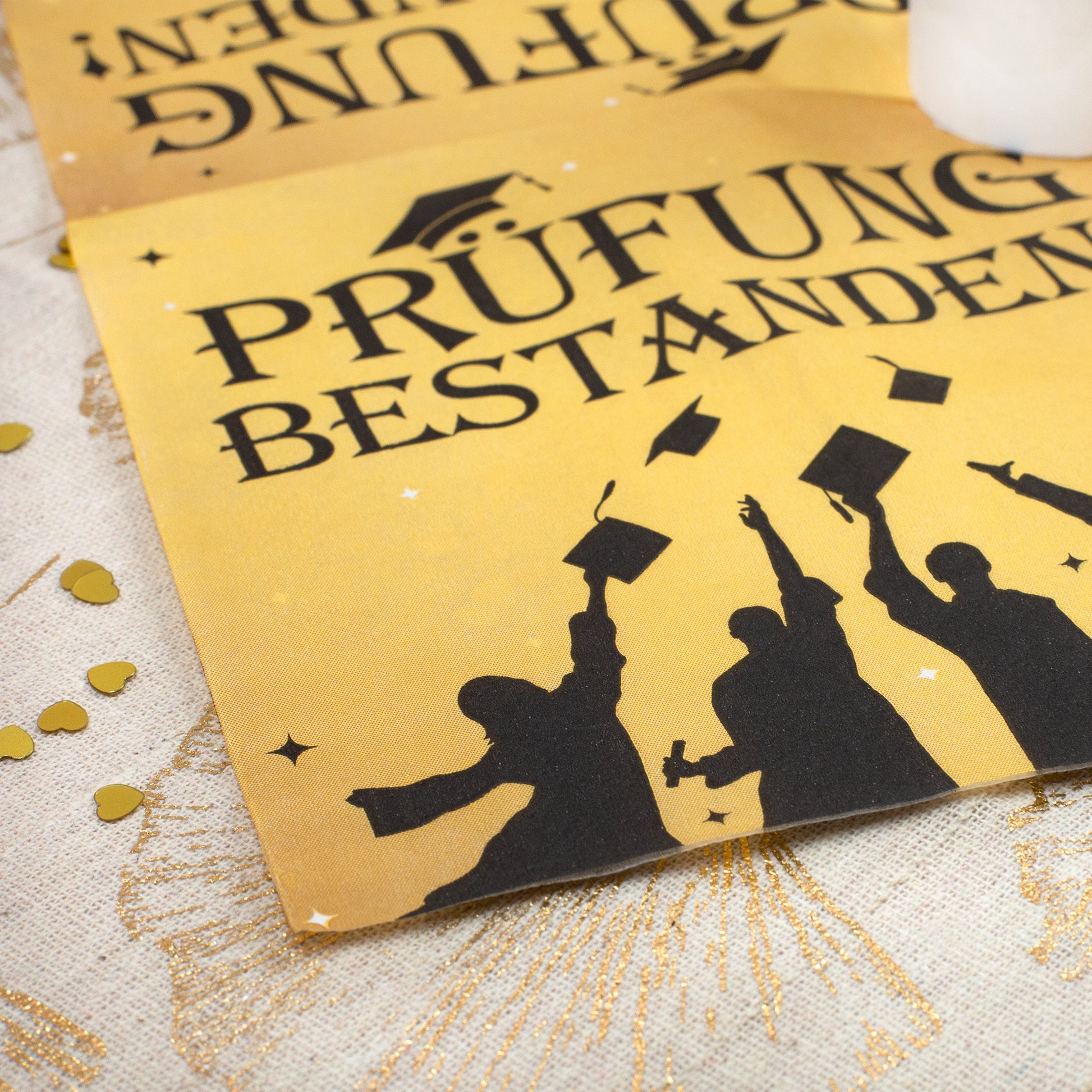 Detailansicht Serviette Prüfung bestanden mit Absolventen-Motiv in Gold und Schwarz – für Abiturfeier
