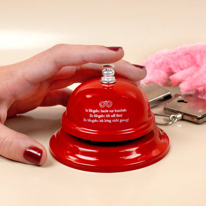 Rote Sex-Klingel mit witzigem Aufdruck „1x kuscheln, 2x Sex, 3x nicht genug“ – Hand drückt die Klingel