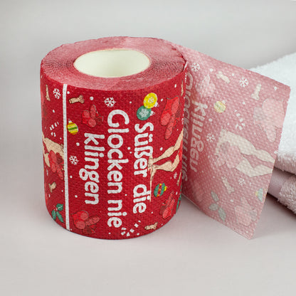 Toilettenpapierrolle Weihnachten rot mit Spruch „Süßer die Glocken nie klingen“ auf weißem Handtuch
