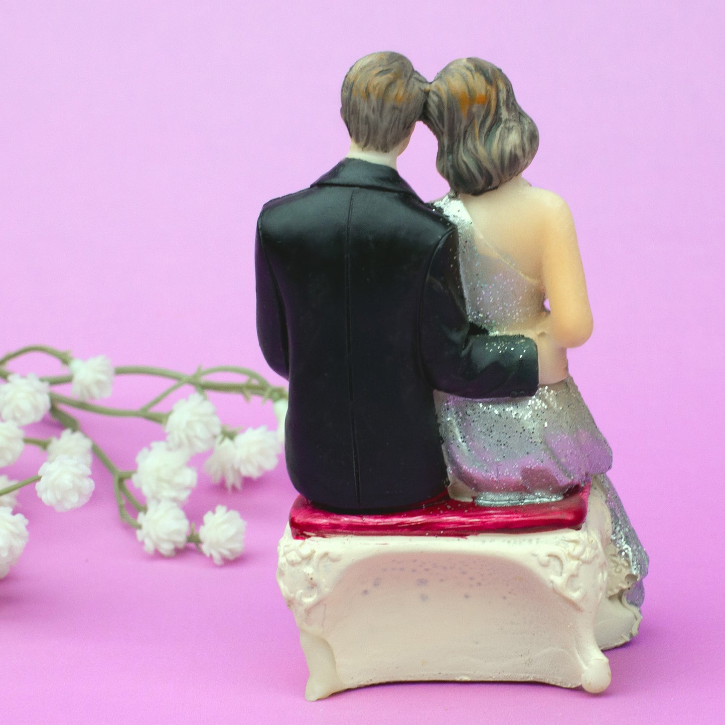 Rückansicht sitzende Hochzeitsfigur – Braut und Bräutigam Arm in Arm auf Bank