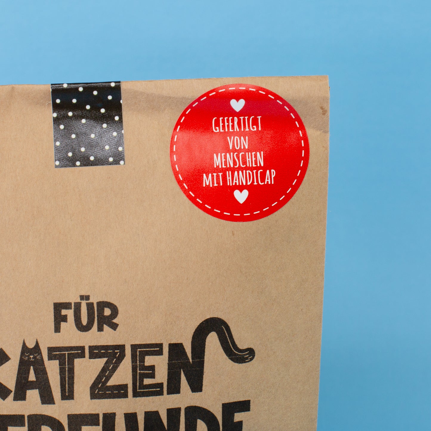 Detailansicht der Ecke der Wundertüte für Katzenfreunde mit Hinweis auf Fertigung durch Menschen mit Handicap
