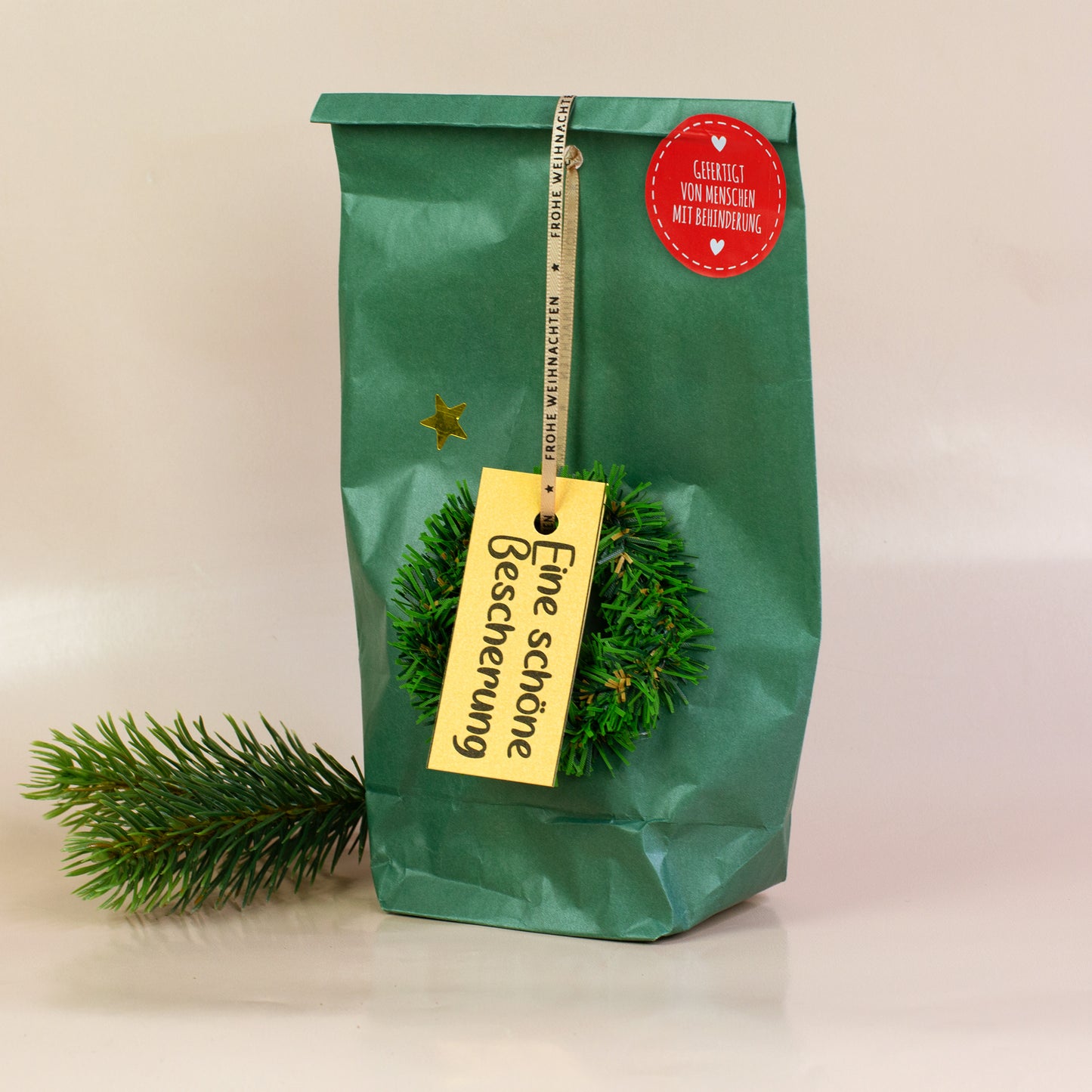 Wundertüte „Eine schöne Bescherung“ mit grünem Papier, Deko-Kranz und Geschenkanhänger